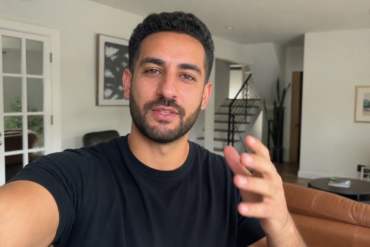 real estate investor casually recording a simple phone video in a home interior, natural light, informal setting, no production equipment visible