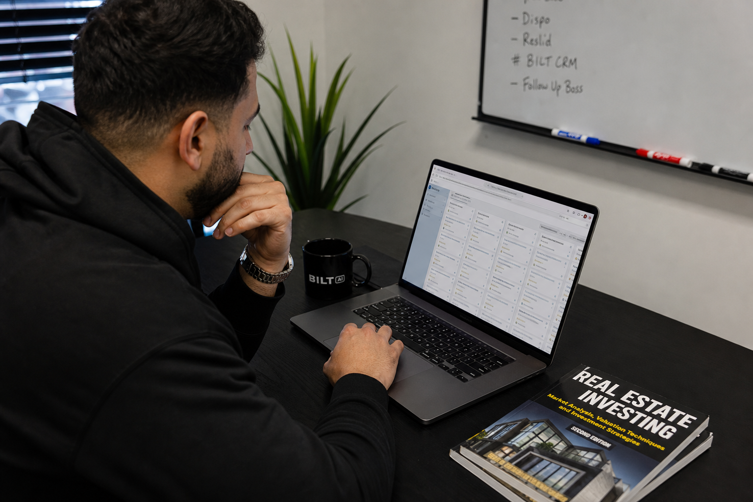 photorealistic image of a real estate investor reviewing organized deal pipeline on laptop, calm office environment, coffee mug, natural lighting, focused expression