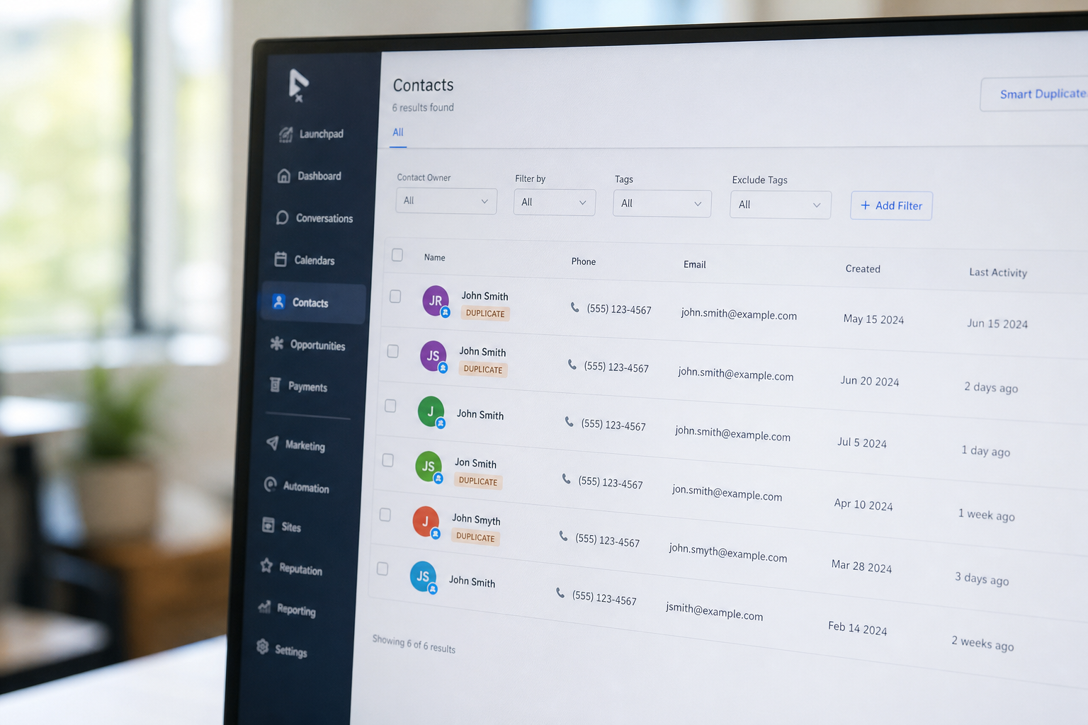 close-up photorealistic shot of a computer screen showing duplicate contact entries in a CRM, slight blur on background office, natural daylight from window